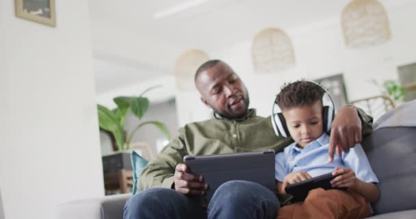 Happy African American Man His Son Sitting Sofa Using Tablet — Stock Video
