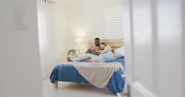 Szczęśliwa Zróżnicowana Para Korzystająca Tabletu Leżąca Sypialni Spędzanie Czasu Domu — Wideo stockowe