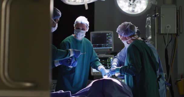 不同的男性助理和女性外科医生在手术室为病人做手术的录像 医疗和保健服务 — 图库视频影像
