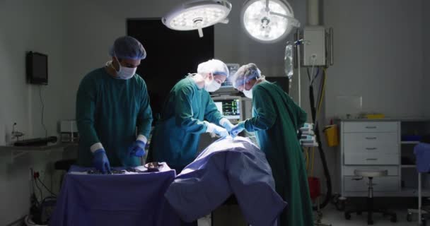不同的男性助理和女性外科医生在手术室为病人做手术的录像 医疗和保健服务 — 图库视频影像
