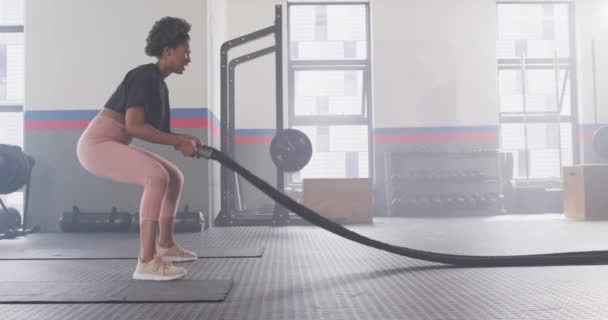 视频侧视图坚定的非洲裔美国女人在健身房工作与争斗的绳索 健身和健康的生活方式 — 图库视频影像