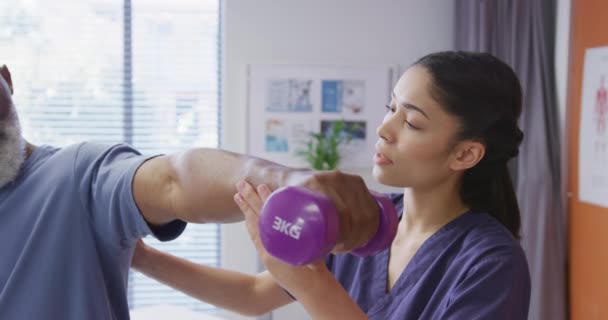 Diverse Female Physiotherapist Senior Male Patient Holding Dumbbell Physical Therapy — Stock Video