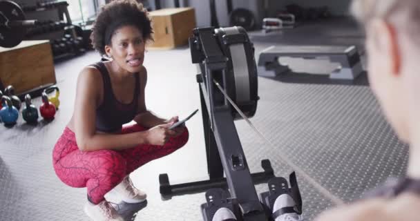 Video Diverse Happy Female Trainer Encouraging Woman Rowing Machine Working — Vídeo de Stock