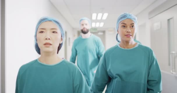 Video Four Diverse Surgeons Surgical Caps Gowns Walking Hospital Corridor — Vídeos de Stock