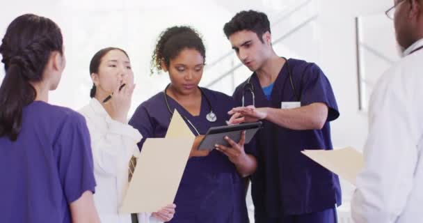 Wideo Różnymi Grupami Lekarzy Patrzących Tabliczki Mówiące Szpitalnym Korytarzu Usługi — Wideo stockowe