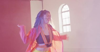 Happy caucasian female dancer dancing alone in dance studio, slow motion. Hobby, art and dance studio concept.