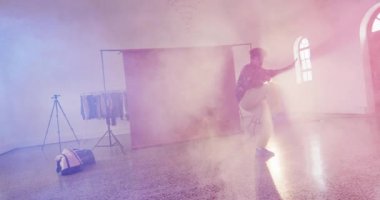 Happy biracial male dancer dancing alone in dance studio, slow motion. Hobby, art and dance studio concept.