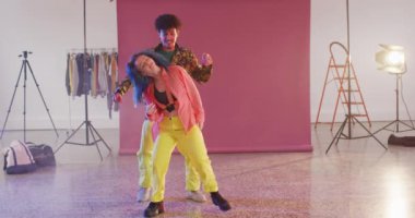 Portrait of happy diverse male and female dancers dancing together in dance studio, slow motion. Hobby, art and dance studio concept.