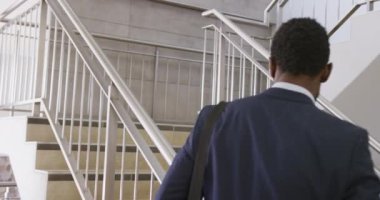 Mutlu Afro-Amerikan iş adamları, ağır çekimde üst kata çıkıyorlar. Modern ofis, iş ve finans sektöründe çalışmak.