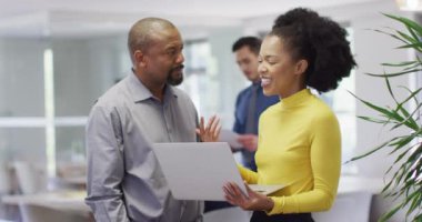 Dizüstü bilgisayar kullanan ve ofiste konuşan bir grup iş adamı, yavaş çekim. Küresel iş, finans ve modern ofiste çalışma.