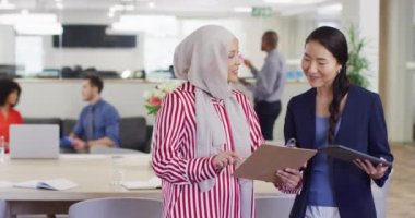 Belgeleri tutan ve ofiste konuşan bir grup iş adamı, yavaş çekim. Küresel iş, finans ve modern ofiste çalışma.