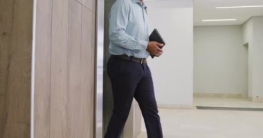 Ofiste asansöre binen çeşitli iş adamları, ağır çekimde. Modern ofis, iş ve finans sektöründe çalışmak.