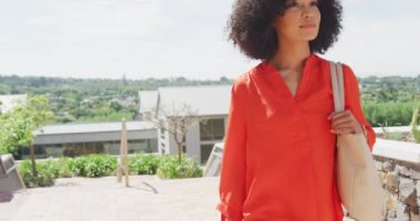 Mutlu Afro-Amerikan iş kadınları ağır çekimde yürüyor ve çantalarını tutuyor. Modern ofis, iş ve finans sektöründe çalışmak.
