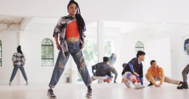 Biracial female dancer stretching with diverse colleagues in dance studio, slow motion. Hobby, art and dance studio concept.