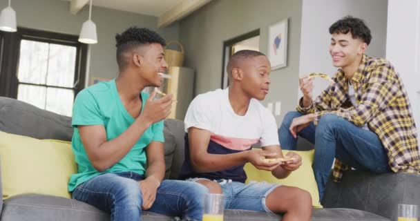 Happy Diverse Male Teenage Friends Eating Pizza Sitting Couch Slow — Wideo stockowe