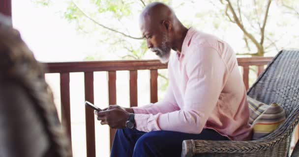 Happy Senior African American Man Log Cabin Using Smartphone Balcony — Vídeo de Stock