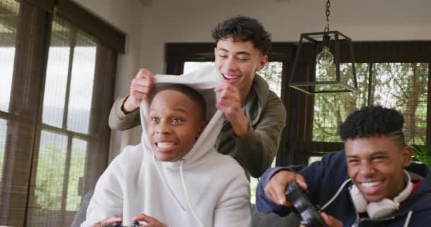 家庭でビデオゲームをしている幸せな多様な男性の十代の友人 スローモーション 家で一緒に質の高い時間を過ごす — ストック動画