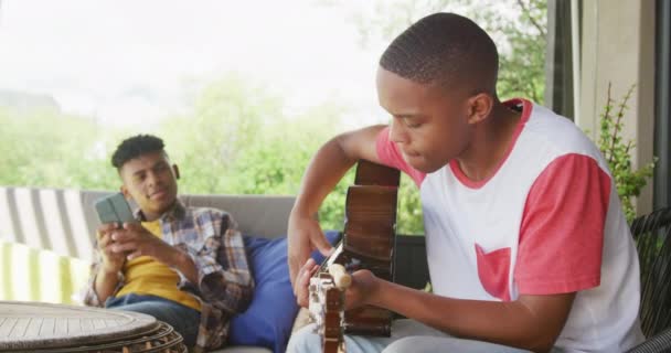 Happy African American Male Teenage Friends Playing Guitar Home Slow — Vídeos de Stock