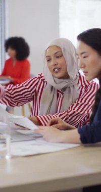 Ofiste iş tartışan çeşitli iş adamlarının dikey videosu. Modern ofis, iş ve finans sektöründe çalışmak.