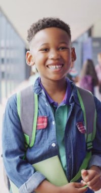 Mutlu Afro-Amerikan okul çocuğunun okuldaki portresinin dikey videosu. Eğitim, kapsayıcılık, okul ve öğrenme kavramı.