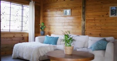 General view of living room with sofa and coffee table in log cabin, slow motion. Interior, design and countryside concept.