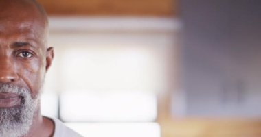 Portrait of happy senior african american man spending time in log cabin, slow motion. Free time, domestic life and leisure concept.