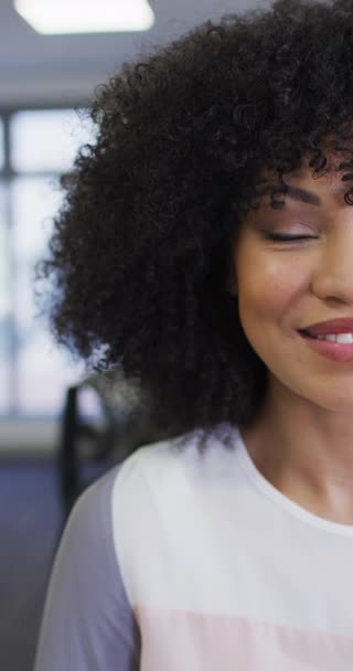 アフリカ系アメリカ人のビジネスマンの女性がオフィスでカメラを見て笑顔の縦ビデオ 現代のオフィス ビジネス 財務の概念で働く — ストック動画
