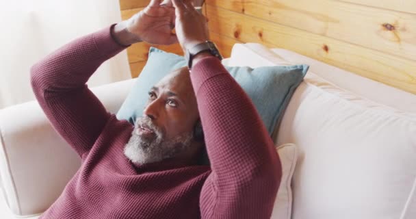 Happy Senior African American Man Log Cabin Laying Sofa Using — Stockvideo