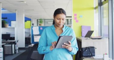 Portrait of african american businesswoman using tablet at office, slow motion. Working at office, business concept.