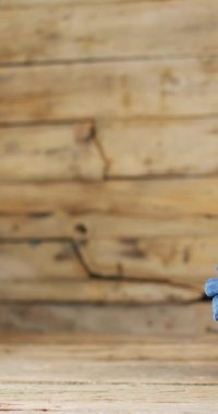 Vertical video of folded jeans with different shades on wooden background with copy space. Denim day, material, style and design concept.