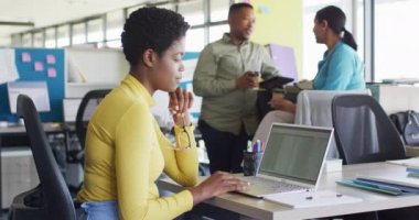 Portrait of african american businesswoman using laptop at office, slow motion. Working at office, business concept.