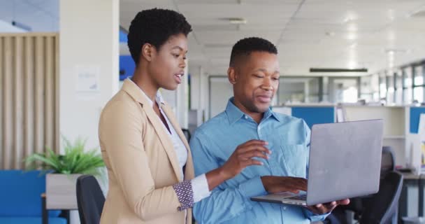 アフリカ系アメリカ人はオフィスでノートパソコンを使う オフィスで働くこと ビジネスコンセプト — ストック動画