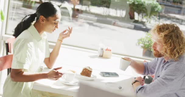 多種多様なカップルがコーヒーを飲みながらカフェのテーブルでお話をしています 都市の休憩 地元のビジネスとおもてなしのコンセプト — ストック動画