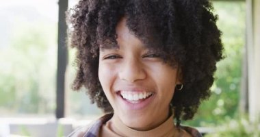 Mutlu Afro-Amerikan genç kız portresi, gülümseyen ve gülen, yavaş çekim. Boş zaman, ev konseptinde kaliteli zaman geçirme.