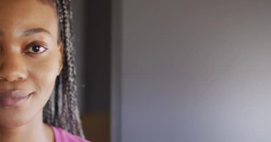 Afro-Amerikan kadının mutlu portresi kameraya bakıyor ve odunlukta gülümsüyor, ağır çekimde. Yaşam tarzı, ev hayatı, kırsal ve doğa kavramı.