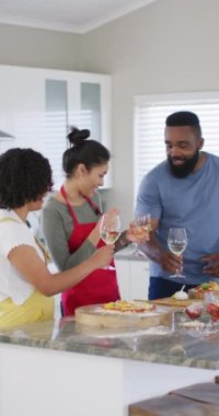 Pizza yapan, şarap içen, yavaş çekim yapan çeşitli kadın ve erkek arkadaşlarının dikey videosu. Aşçılık, arkadaşlık ve yaşam tarzı kavramı.