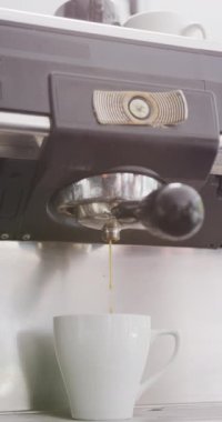 Kahve makinesinin kafede kahve yaparken çekilmiş dikey videosu. Kafe, kahveci ve iş konsepti.