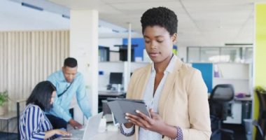 Portrait of african american businesswoman using tablet at office, slow motion. Working at office, business concept.