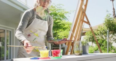 Güneşli bir günde evde ve bahçede mutlu bir çift videosu. Etkin emeklilik ve yaşam tarzı kavramı.