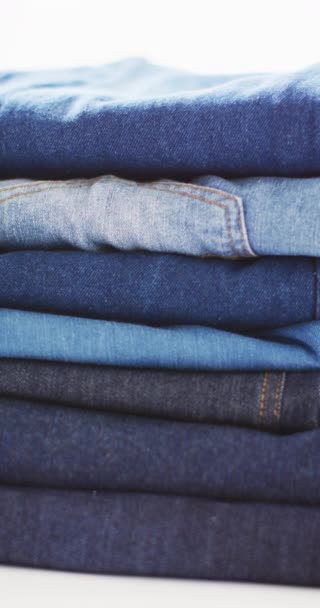 Verticale Video Van Gevouwen Jeans Met Verschillende Tinten Witte Achtergrond — Stockvideo