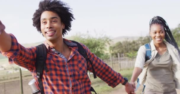 Gelukkig Afrikaans Amerikaans Echtpaar Met Rugzakken Samen Wandelen Zonnige Dag — Stockvideo