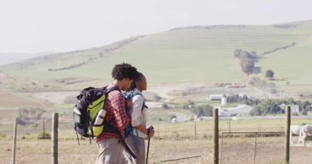 Happy African American Couple Backpacks Hiking Trekking Poles Together Slow — стокове відео
