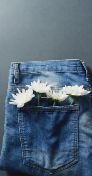 Verticale Video Van Jeans Met Witte Bloemen Grijze Achtergrond Met — Stockvideo