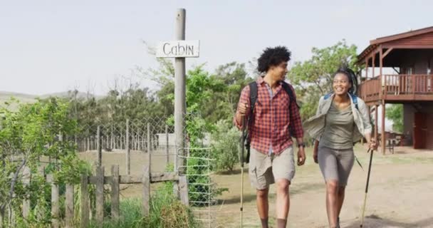 Happy African American Couple Backpacks Hiking Trekking Poles Together Slow — Stockvideo