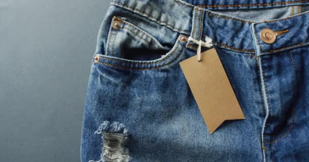 Gros Plan Jeans Avec Étiquette Sur Fond Gris Avec Espace — Video