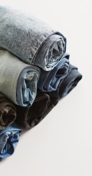 Verticale Video Van Gevouwen Jeans Met Verschillende Tinten Witte Achtergrond — Stockvideo