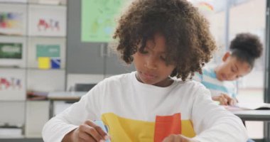 Sınıfta masa başında çalışan gülümseyen Afrikalı Amerikalı öğrencinin video portresi. Eğitim, çocukluk, kapsayıcılık, ilkokul ve öğrenim kavramı.