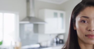 Portrait of happy biracial woman looking at camera and smiling, with copy space, slow motion. Spending quality time at home, domestic life and lifestyle concept.