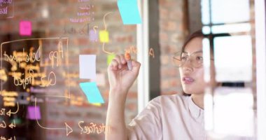 Thoughtful asian creative businesswoman brainstorming ideas in casual office, slow motion. Start up business, work and communication concept.