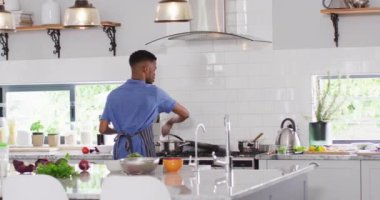 Afro-Amerikalı adam mutfakta yemek hazırlıyor. Yaşam tarzı, yaşam tarzı, ev kavramında boş zaman geçirme.
